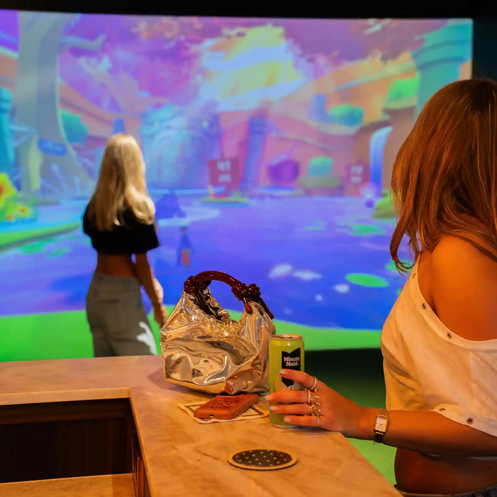 Twee vriendinnen spelen een kleurrijk spel op de golfsimulator